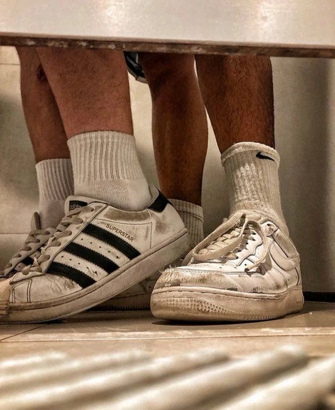A pair of shoes with socks on them sitting on a bench.
