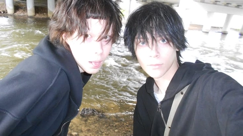 A couple of young men standing next to each other.