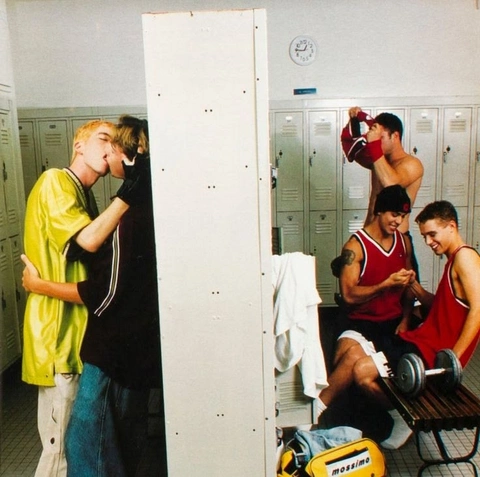 A group of young men standing next to each other in a locker room.