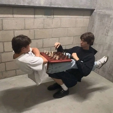 A group of young men playing chess on a table.