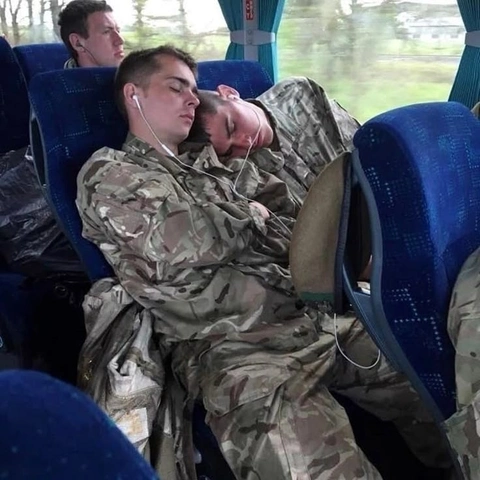 A group of soldiers sleeping on a bus.