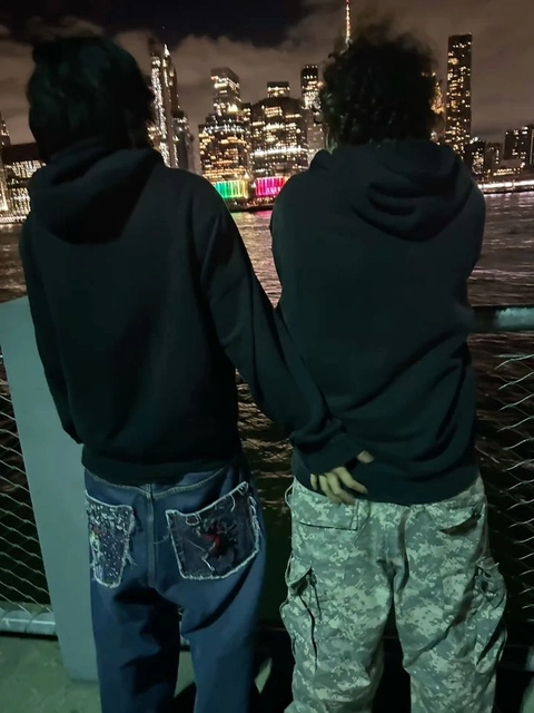 A couple of people standing next to each other in front of a city.
