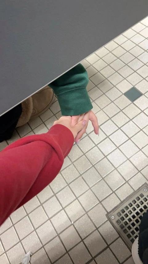 A reflection of a person's hand on a tiled floor.