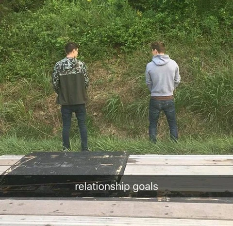 A group of men standing next to each other on a train track.