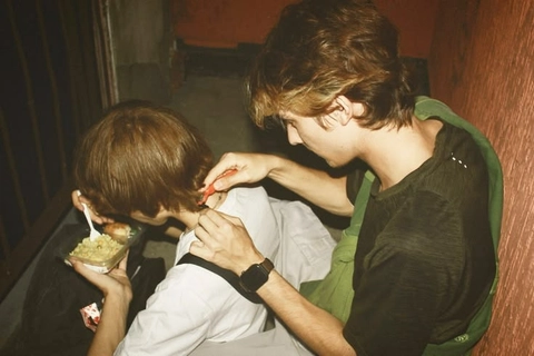 A group of young men eating food in a theater.