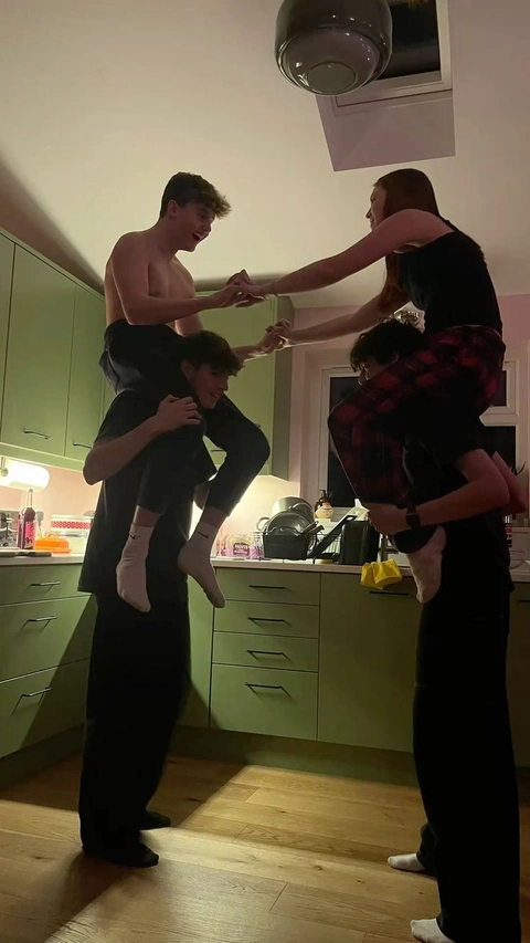 A group of people standing on top of each other in a kitchen.