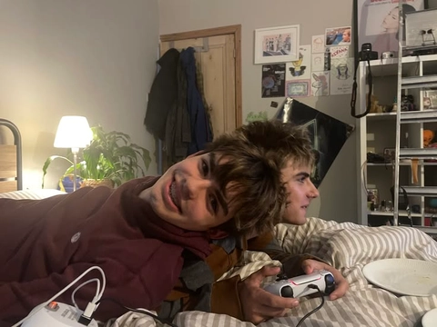 A group of people sitting on top of a couch playing video games.