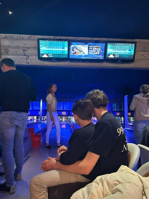 A group of people sitting in a bowling alley.